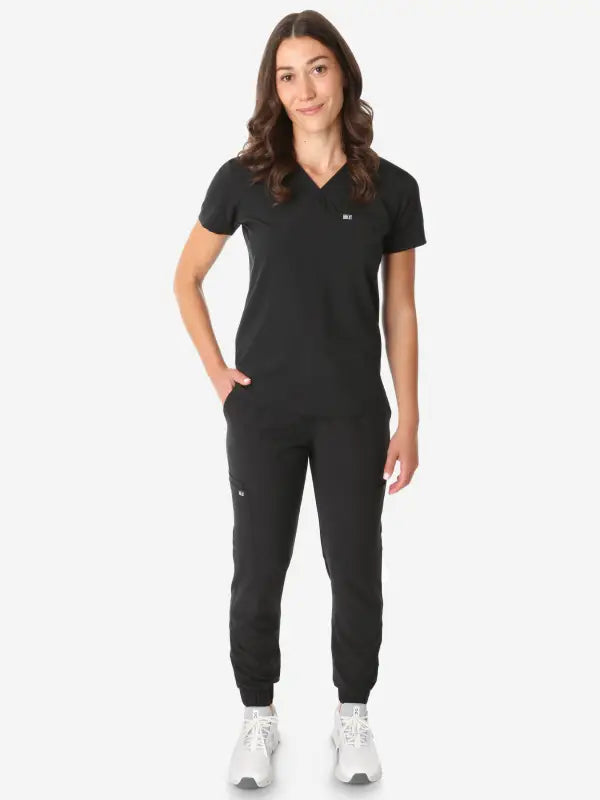 Black athletic jumpsuit with short sleeves, perfect for women’s tuckable one-pocket scrub