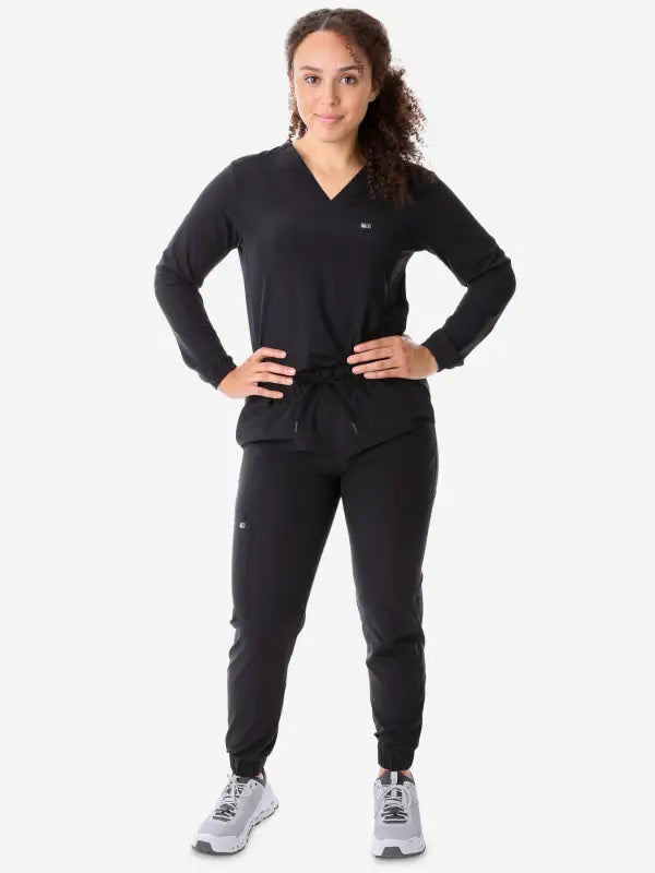 Black athletic tracksuit featuring a women’s long-sleeve scrub top and jogger pants