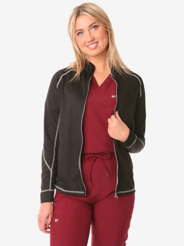 Black women’s scrub jacket with contrast piping over burgundy scrubs for a stylish look