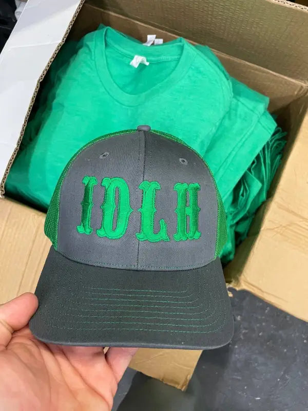 Black baseball cap featuring green IDLH font logo embroidery on the front