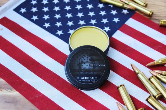 Black container of Freedom Blend Extra Strong Moustache Wax with yellow contents visible