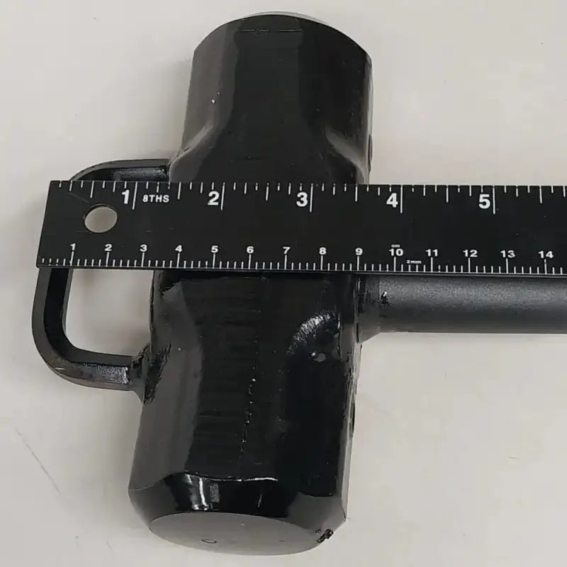 Black cylindrical mug with a ruler over it beside Leatherhead Tools Halligan Entry Tool