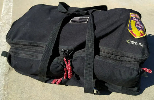 Black Wildland Gear Bag with patches, zipper pockets, and hand grips for outdoor use