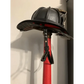 Black firefighter helmet on red pole featuring smooth leather chin straps for durability