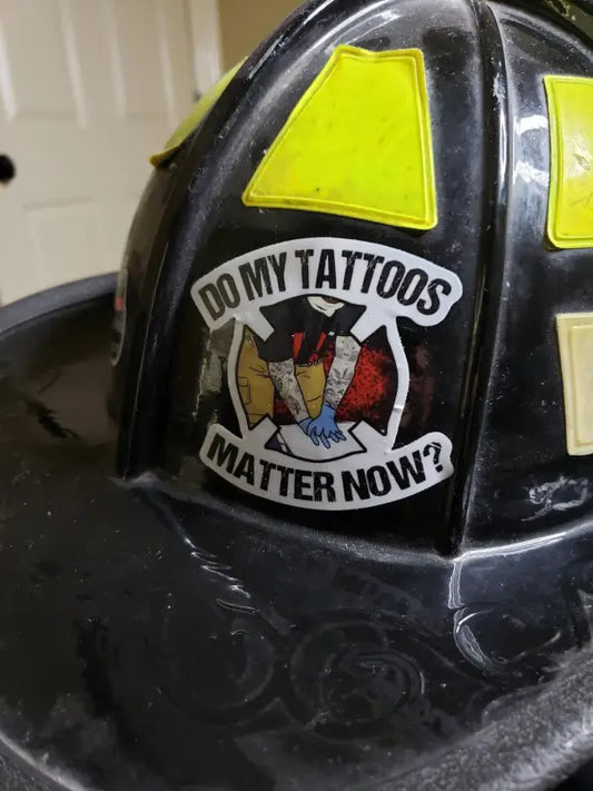 Black firefighter helmet with a Do My Tattoos Matter Now sticker, weather-resistant ink design