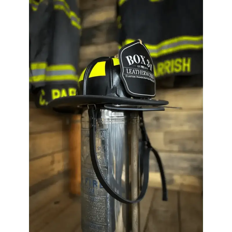 Black firefighter helmet with yellow reflective stripes and leather chin straps