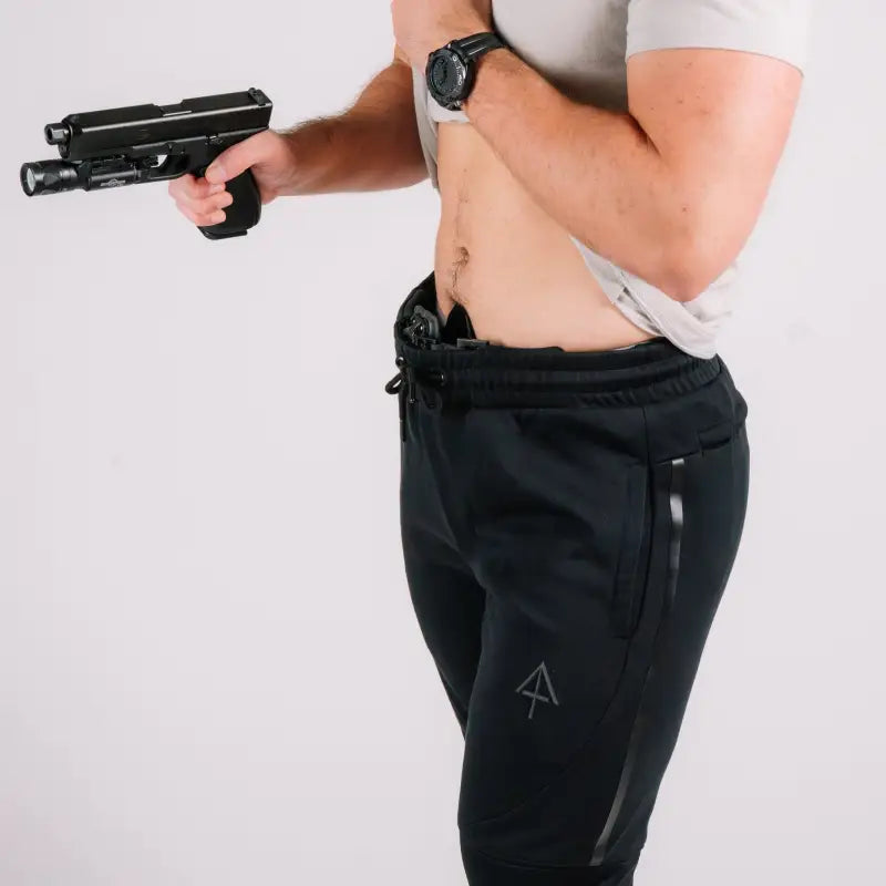 Black handgun with tactical light on Carrier Joggers Mk.II - Midnight Black by Arrowhead Tactical Apparel