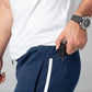 Black handgun drawn from navy blue joggers featuring patented carrier retention