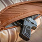 Black handgun in brown mesh holster inside ECHO EDC Backpack for concealed carry