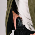 Black handgun in hand pocket of Tactical Jacket Bravo for covert concealment