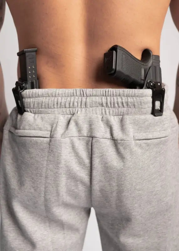 Black handgun tucked in Carrier Sweatpants - Carbon Grey with patented carrier retention