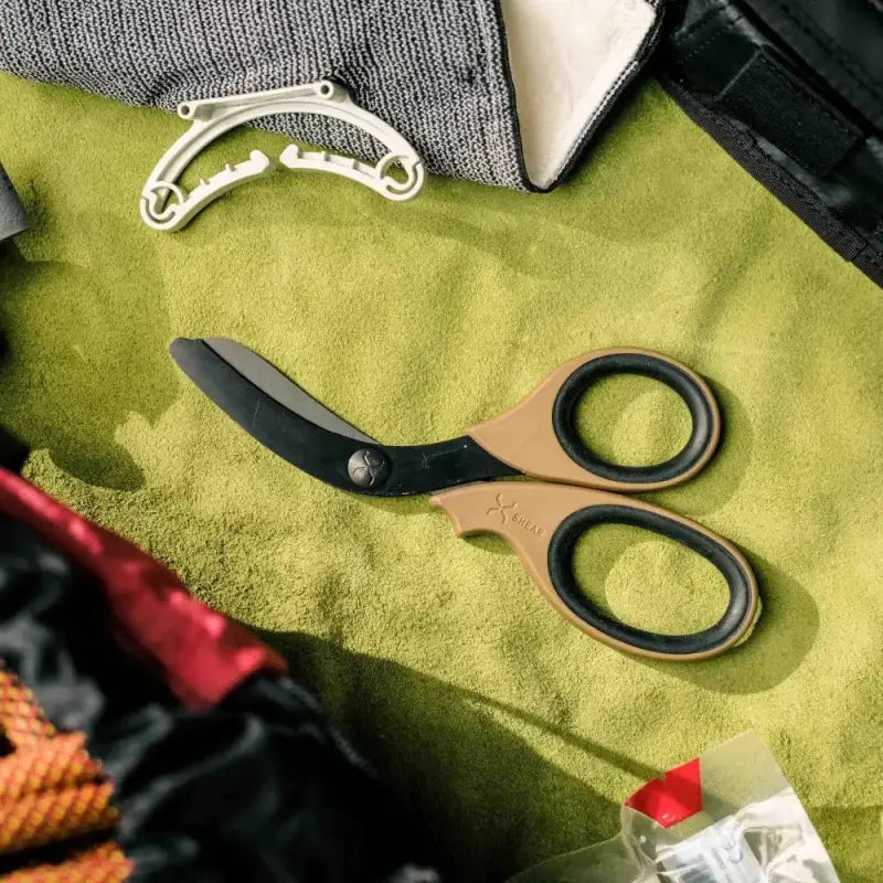 Black-handled XShear 7.5” heavy duty trauma shears on lime green fabric with black titanium coated blades