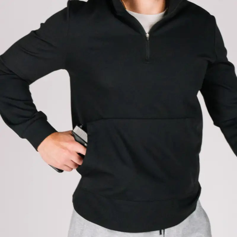Black durable quarter zip hoodie with a concealed gun in the pocket for style and security