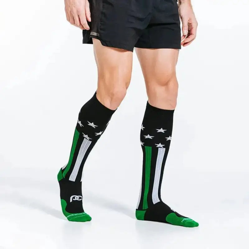 Black knee-high athletic socks with green and white stripes for first responders