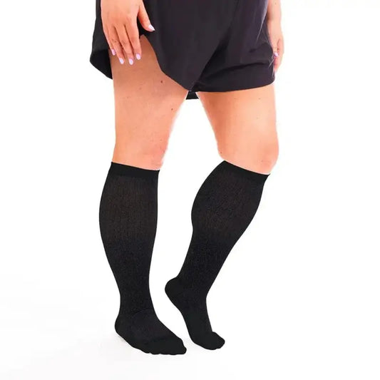 Black knee-high compression socks on legs in shorts, ideal for Marathon Wide-Calf and first responders