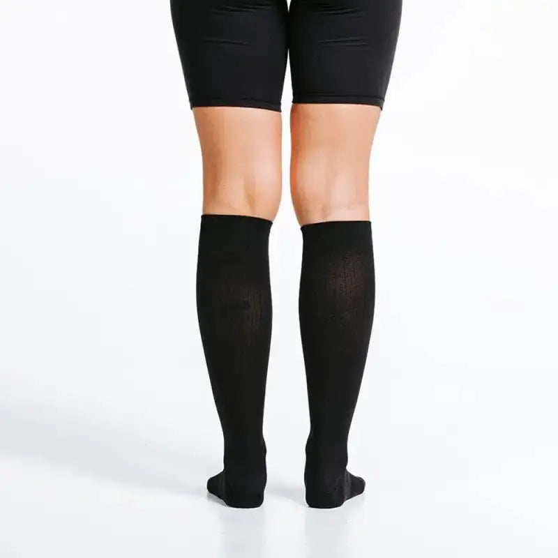 Black knee-high compression socks paired with black shorts for Marathon performance