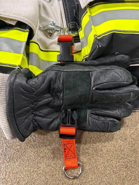 Black leather firefighter glove with orange safety strap attachment for first responders