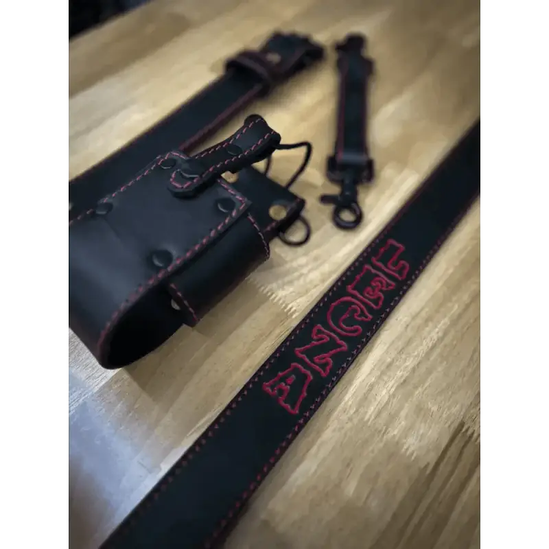 Black leather radio strap featuring red embroidered text for quick attachment