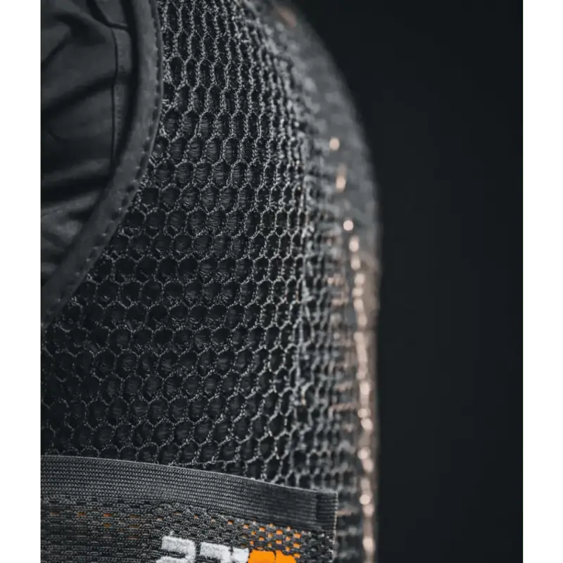 Black mesh fabric of the Maxx-Dri Vest 5.0 with orange and white logo tag