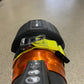 Black and orange ski boot with dials showcasing the innovative extrication tool carrying strap