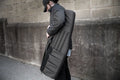 Person carrying a black padded sporting rifle case with durable construction and shoulder strap