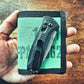 Black folding pocket knife on mint green wallet, Captain Mens Wallet in Coyote Combat Leather