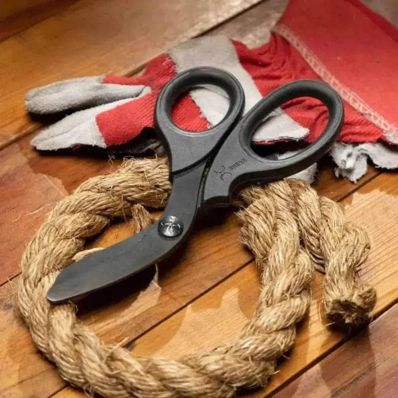 Black scissors on coiled rope, showcasing XShear Heavy Duty Trauma Shears with black titanium coated blades