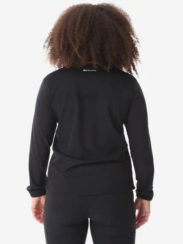 Back view of a women’s long-sleeve scrub top in black for stylish workwear