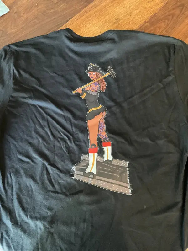 Black level tee featuring a cartoon firefighter on the back from Combat Challenge Firema’am