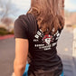 Black Woman’s Skully Tee with white graphic design paired with blue denim shorts