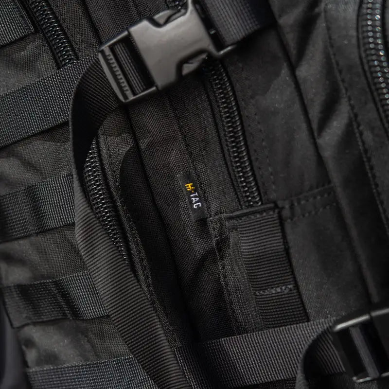 Black tactical backpack showcasing M-Tac Assault Pack with large main zippered compartments