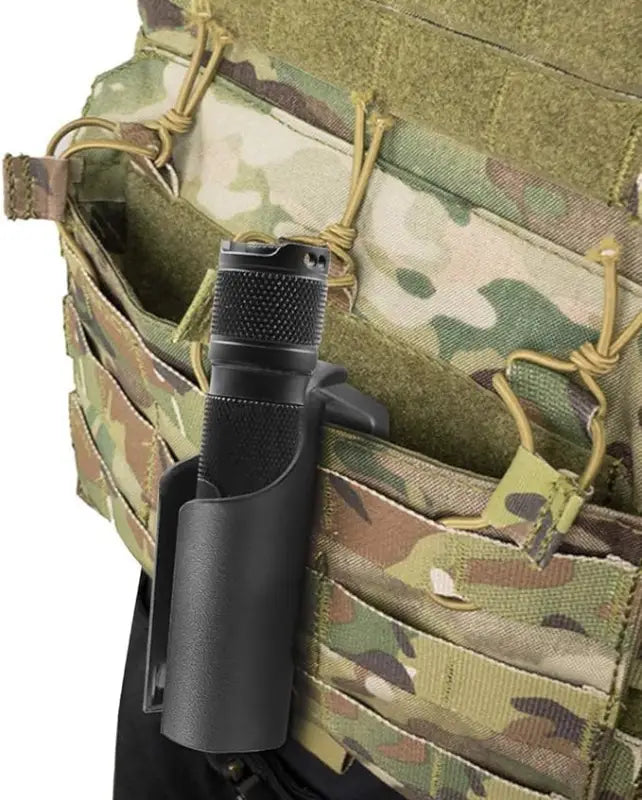 Black tactical flashlight on camouflage gear with Engineered Plastic Clip-on Holster