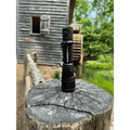 Black Warrior LT-G5 Long Throw Tactical Flashlight on a weathered tree stump
