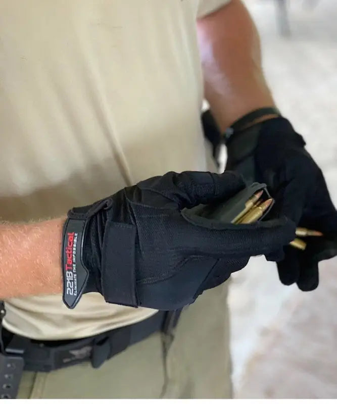 Black tactical glove from Exxtremity Patrol Gloves 2.0 gripping ammunition with hands-free hilight P3X