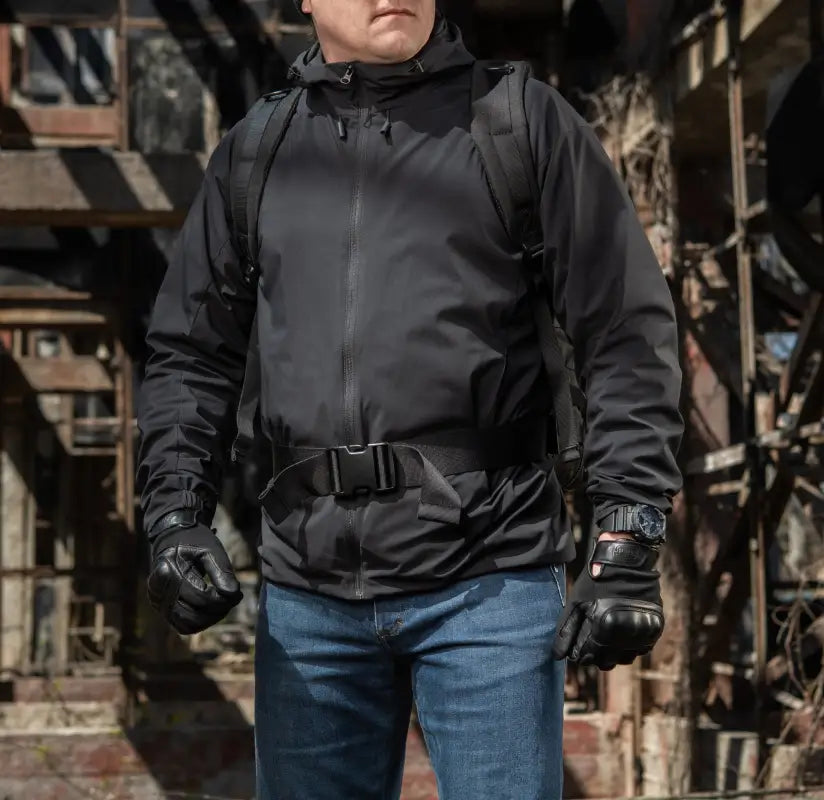 Black tactical jacket with utility belt over blue jeans featuring M-Tac Assault Pack compartments