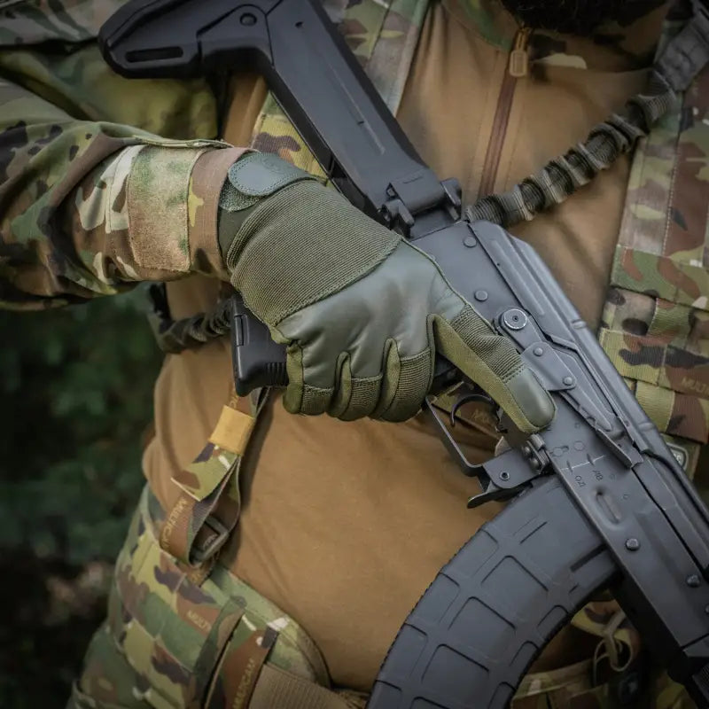 Black tactical rifle held by a gloved hand wearing M-Tac Gloves Police Gen.2