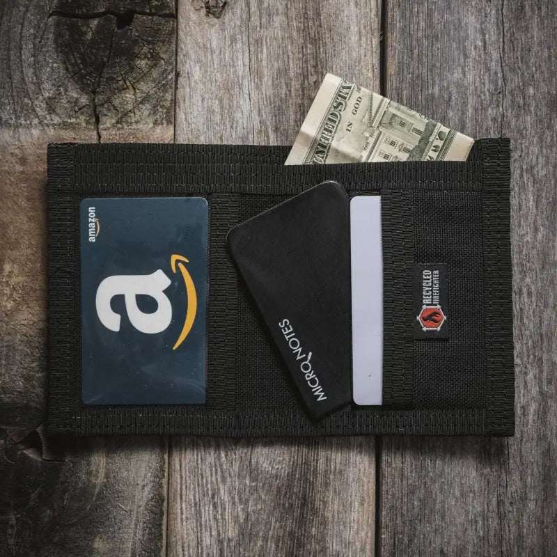 Black wallet in Coyote Combat Leather holds an Amazon gift card and payment cards