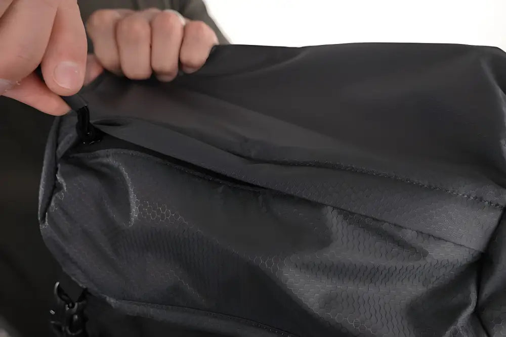 Black waterproof fabric being held for the SUMMIT Discreet Rifle Backpack