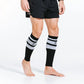 Black and white striped calf compression sleeves on bare legs for athletic support