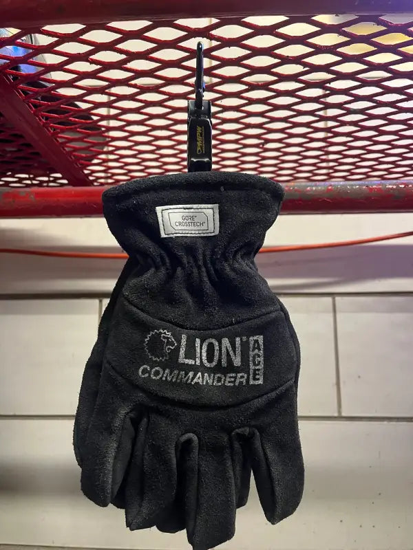 Black work glove hanging from a hook on high-grade metal Glove Clamp, ideal for first responders