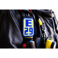 Blue and white E29 logo badge on dark fabric for IdentiFire SCBA Accountability Shoulder Strap