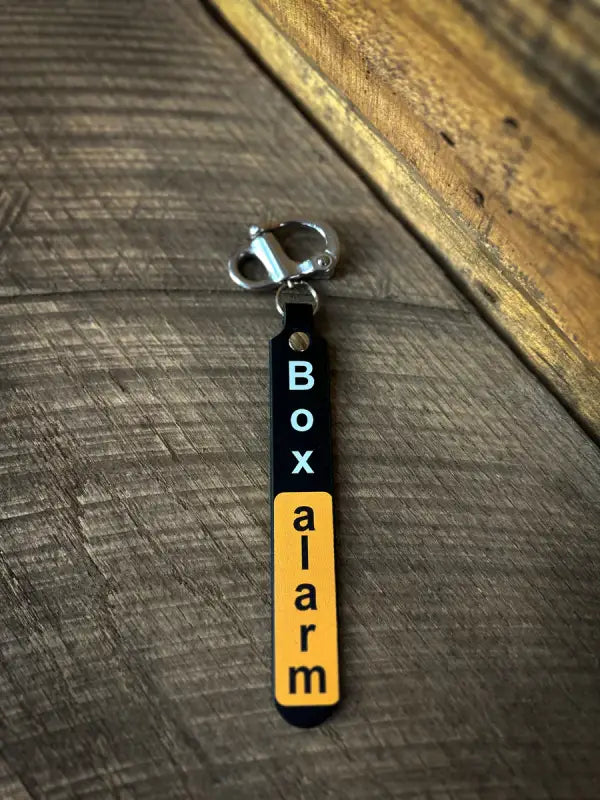 Box alarm keychain with black and orange text for Hi-Def SCBA Quick Release Designs