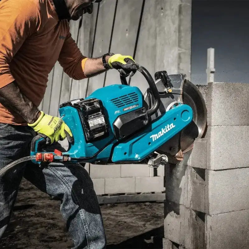 Bright blue Makita GEC01PL4 80V XGT® Brushless power saw cutting concrete blocks