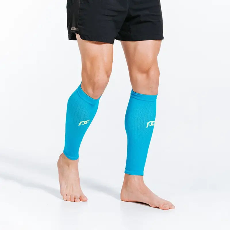 Bright turquoise calf compression sleeves worn on bare legs with black shorts