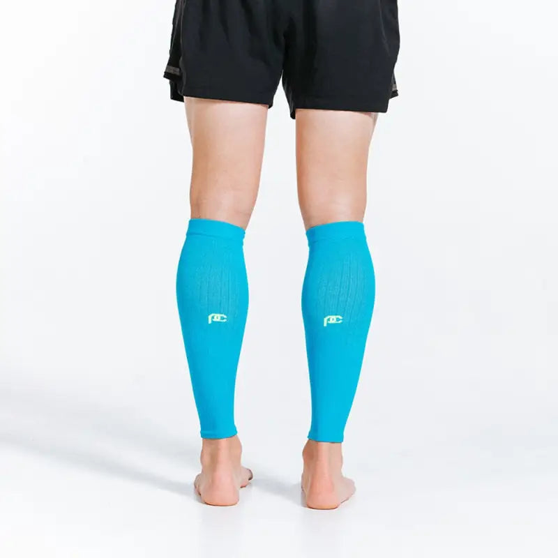 Bright turquoise calf compression sleeves paired with black shorts for athletic wear