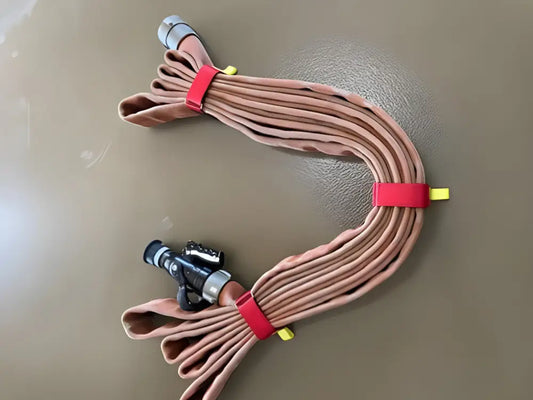 Brown fire hose with metal nozzle bundled in an S-shape with red individual hose strap