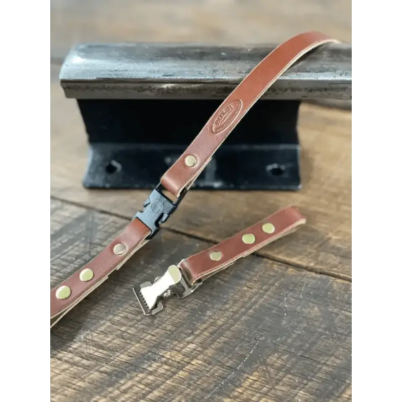 Brown leather chin strap with metal buckle and brass rivets for a smooth finish