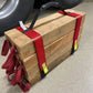 Bundle of firewood secured with red cribbing strap short for easy transport