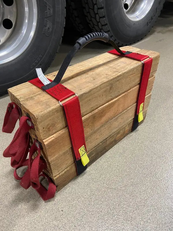 Bundle of firewood secured with red cribbing strap short for easy transport