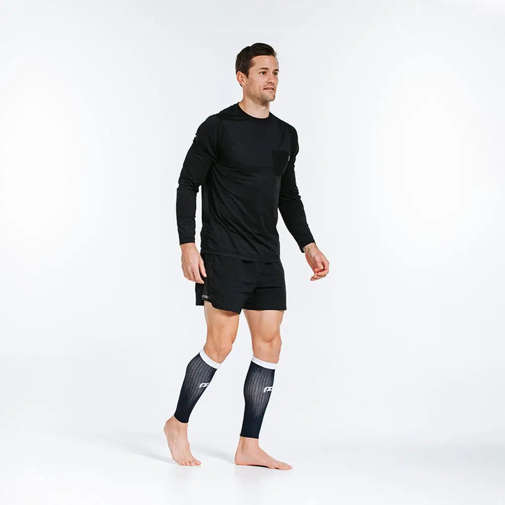 Athletic compression calf sleeves in Navy over White worn with black workout attire